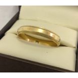 A 14ct gold wedding band with channeled design. Ring size U. Total weight approx. 3.8g.
