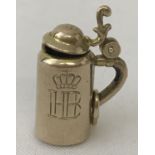 A 9ct gold stein charm with engraved HB monogram and crown to front. Hinged lid opens.