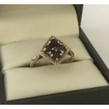 A 9ct gold vintage style, garnet set dress ring. Diamond shaped mount set with 4 round cut garnets.