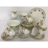 A Victorian ceramic tea set with gilt detail and decorative floral swag design.