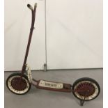 A vintage Triang metal framed scooter, painted red.
