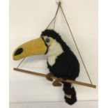 A vintage toucan soft toy, on a hanging perch, by Merrythought.