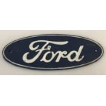 An oval shaped painted cast iron Ford wall plaque, in blue and white.