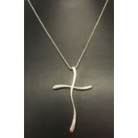 A large modern design cross pendant on a 16" fine snake chain.