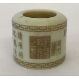 A Chinese white jade archers ring with engraved calligraphy detail.