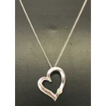 A 9ct white gold open heart shaped pendant set with single diamond, on a 18" fine curb chain.