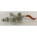 A decorative white metal babies rattle with whistle and coral handle/teether.