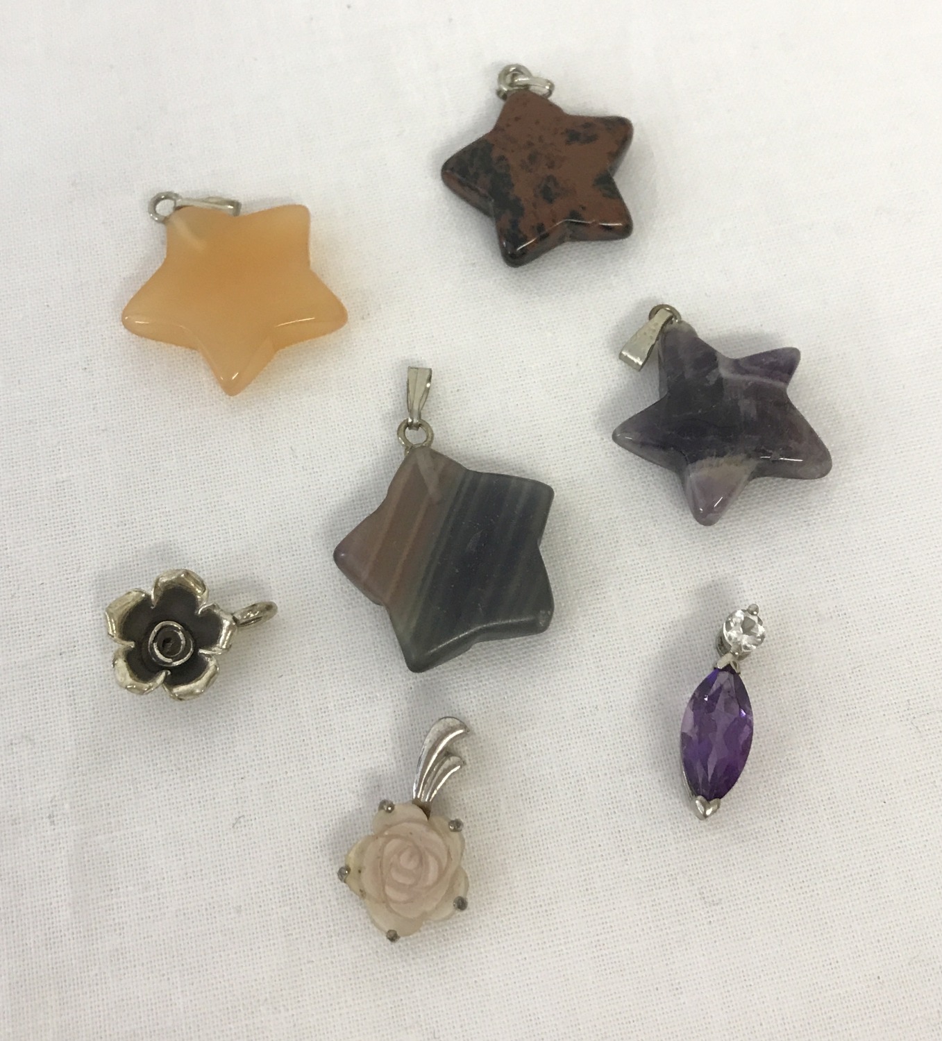 7 silver and white metal pendants most set with natural or semi precious stones.