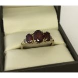 A 9ct gold garnet and diamond dress ring.