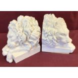 A pair of white alabaster lion shaped book ends.