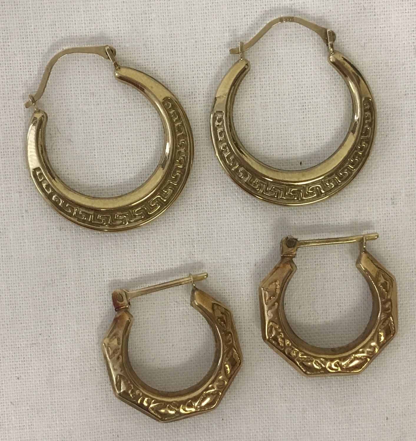 2 pairs of creole style 9ct gold earrings. One pair with Greek key decoration.