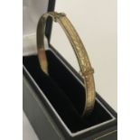 A vintage 9ct gold expanding bangle with heart decoration. Marked 9ct gold to inside.