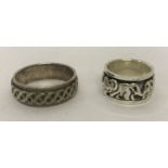 2 silver spinner band rings. One with elephant decoration the other with a Celtic design.