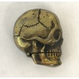 A novelty brass vesta case in the shape of a skull.