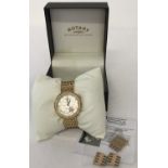 A ladies modern wristwatch by Rotary. Cushion style satin finish white face with gold tone flower.