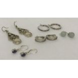5 pairs of silver and white metal earrings in drop, stud and hoops styles.