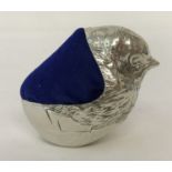 A 925 silver pin cushion in the shape of a chick hatching from an egg.