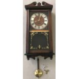 A dark wood cased, President 31 day, wall hanging clock with glass panelled door.