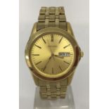 A men's Seiko wristwatch with gold tone case and stainless steel strap.