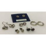 6 pairs of silver and white metal earrings in drop, hoop and stud styles.