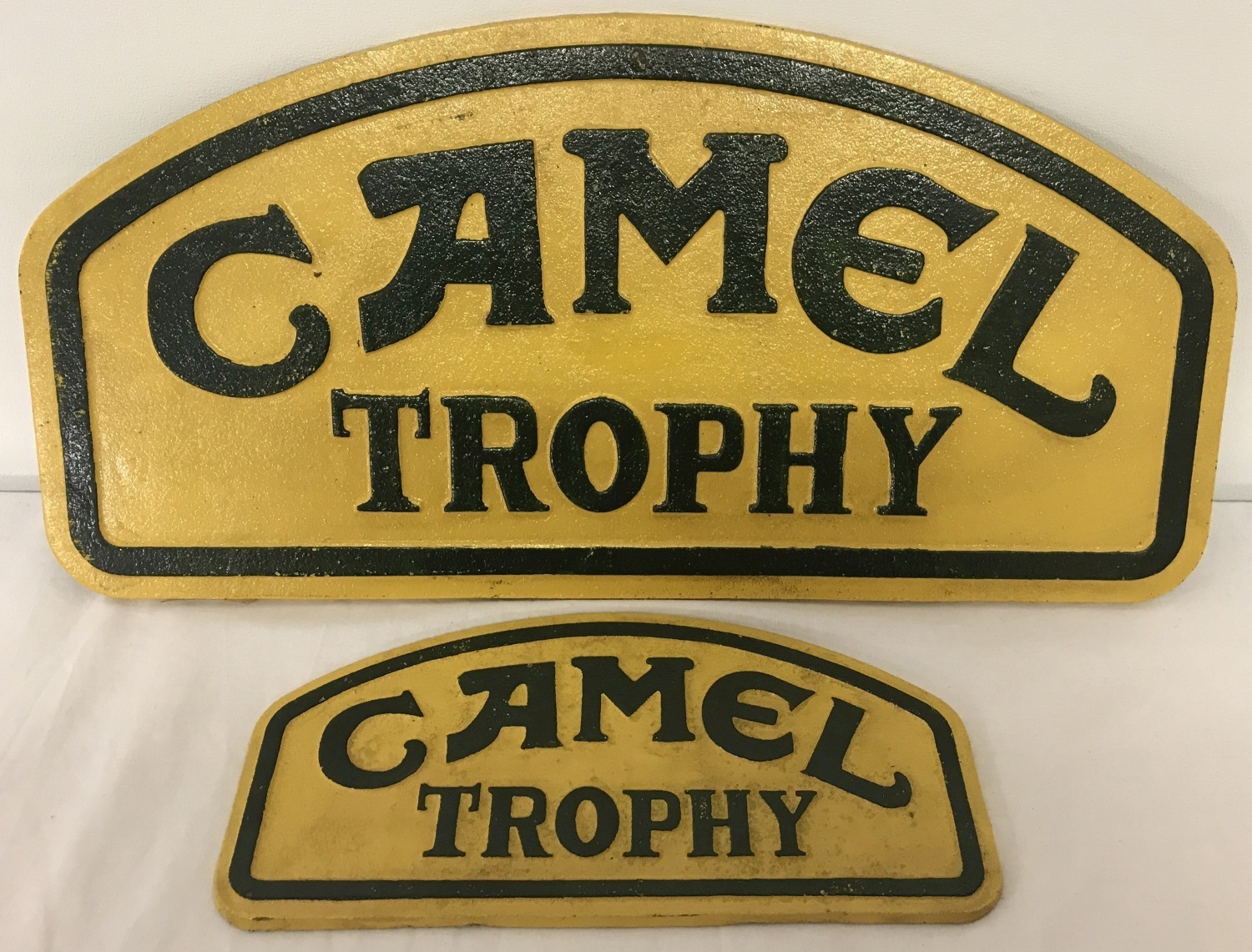 2 painted cast Iron dome topped wall hanging "Camel Trophy" signs.