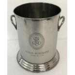 A circular 2 handled Louis Roederer champagne cooler with engraved detail to front.