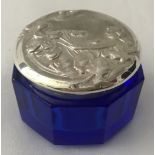 A small silver topped glass pot with Art Nouveau style detail to lid.