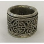A Chinese white metal Archers ring with central rotating panel decorated with shou characters.
