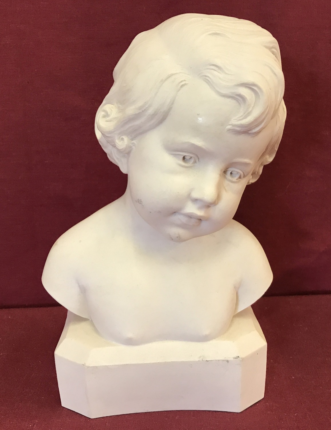 A white alabaster bust of a child, signed to side D.David.