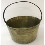 A heavy antique brass, fixed riveted handle cooking pan.