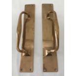 A pair of brass door handles mounted on finger plates, with 4 fixing holes.