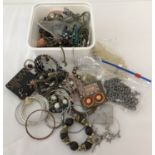 A tub of mixed costume jewellery necklaces, bangles and earrings, some still on original cards.