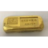 A Chinese gold coloured ingot with impressed mark and Chinese symbols.