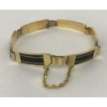 A vintage design 18ct gold and jet 6 panel bracelet with safety chain.
