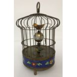 An ornamental wind up birdcage clock with cloisonné panel to base.