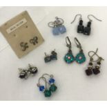 8 pairs of silver and white metal costume jewellery earrings in both stud and drop styles.