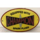 A painted cast iron Champion spark plugs, oval shaped wall hanging plaque.