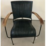 A new wrought iron framed arm chair with wooden arms and petrol blue leather seat and back.