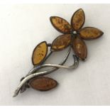 An amber set silver flower brooch. Petals & leaves set with marquise cut amber.