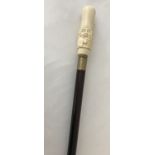 A bone topped walking cane with screw in finial depicting a comical Oriental gentleman.