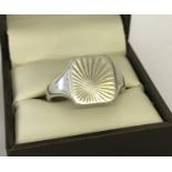 A men's square shaped signet ring with sunray design to top. Size V.