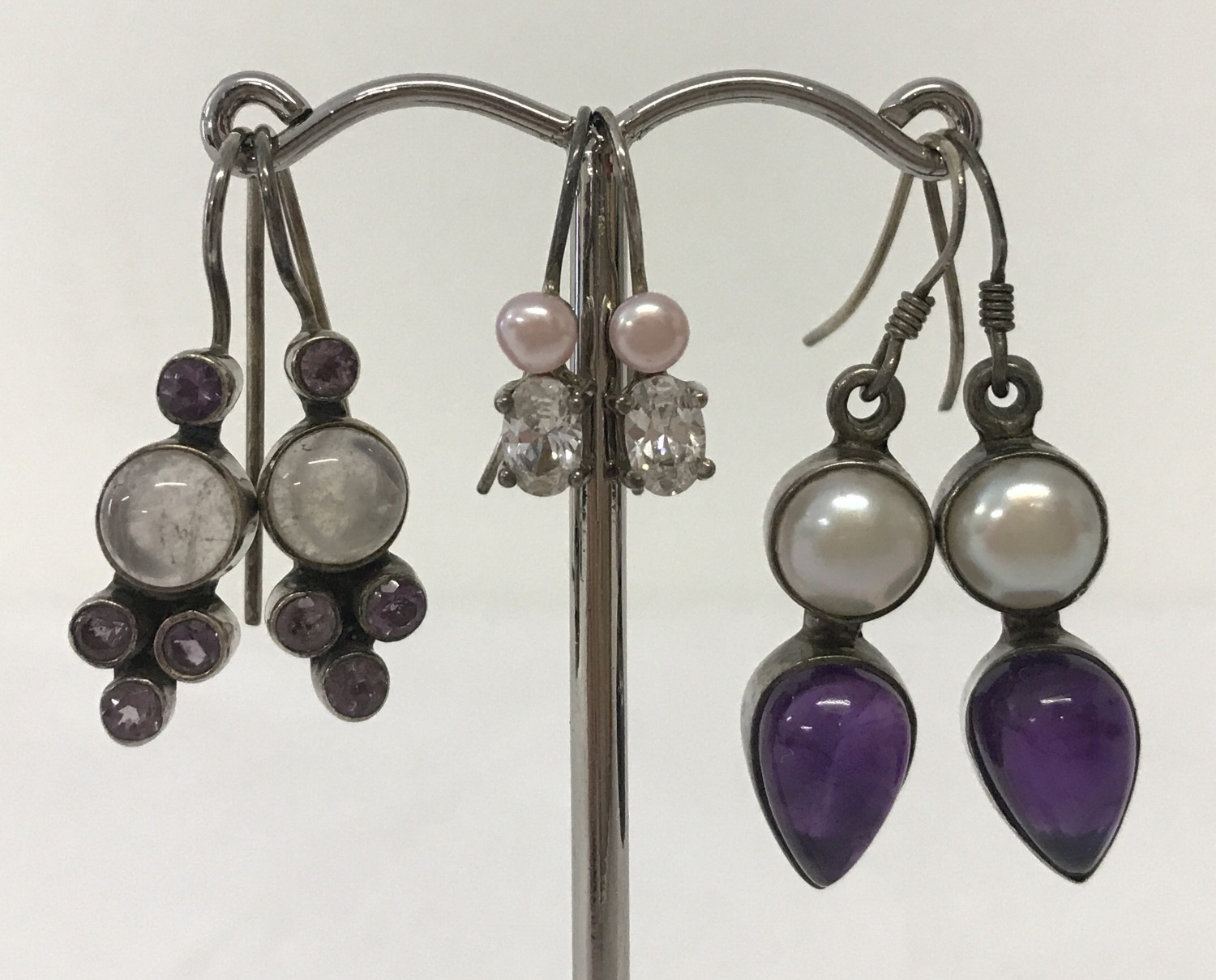 3 pairs of silver earrings set with semi precious stones. All in drop style.