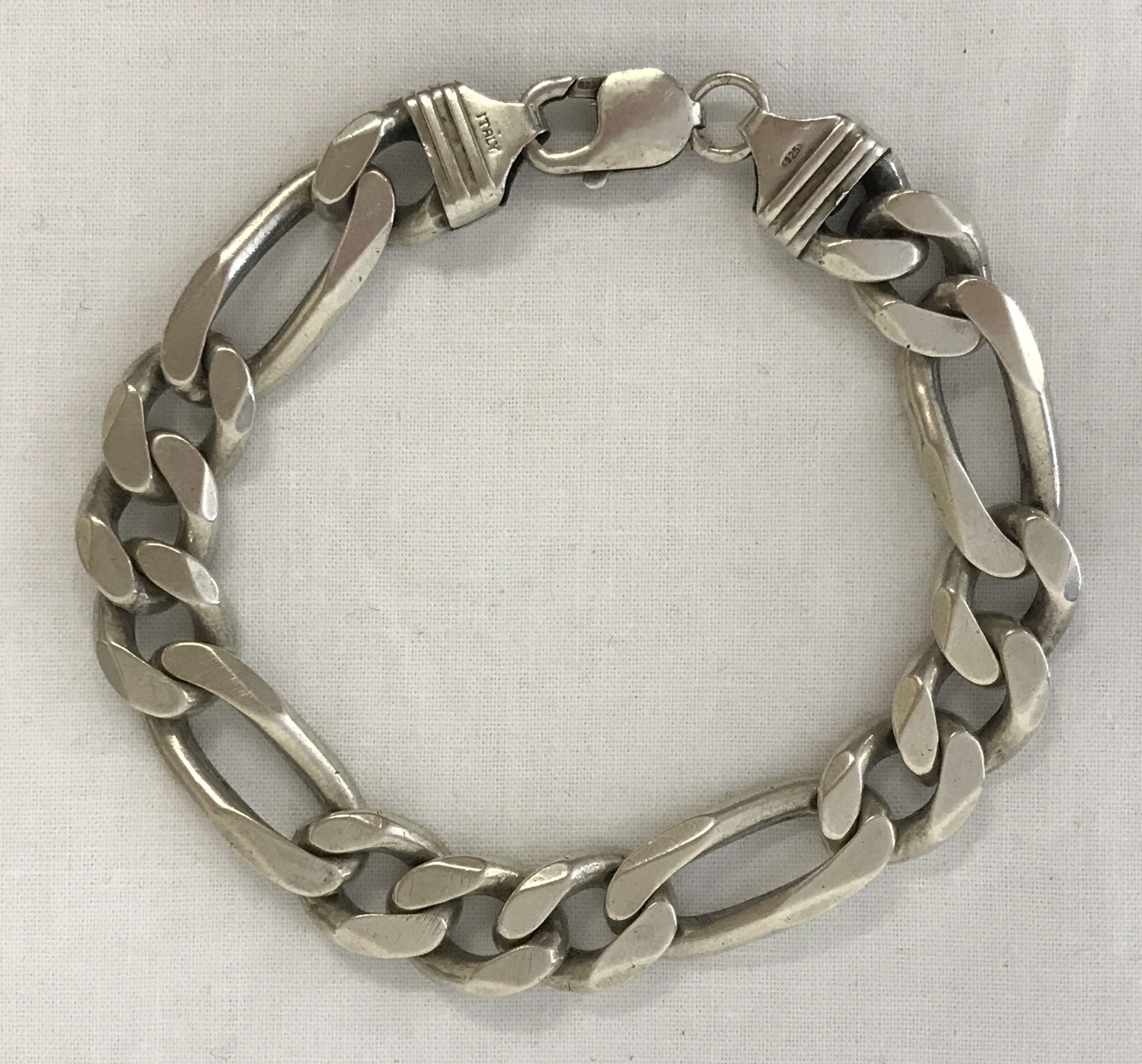 A heavy silver figaro style chain bracelet with lobster style clasp.