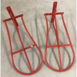 2 wall mountable saddle racks, painted red.