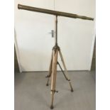A large brass telescope mounted on a wooden height adjusting tripod stand.