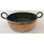 A Victorian copper 2 handled cooking pan with riveted handles.