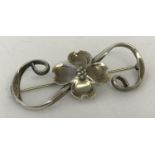 A sterling silver decorative dog flower brooch by Stuart Nye.