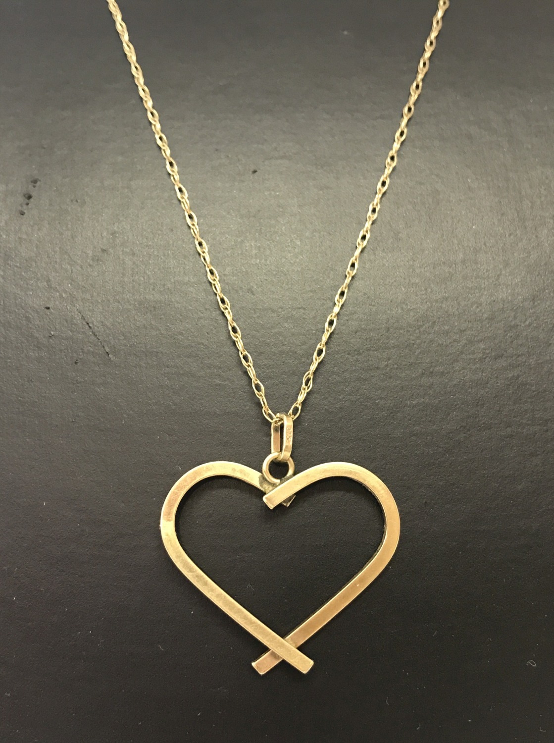 A 9ct gold open heart pendant on a 9ct gold fine rope chain approx. 20" long.