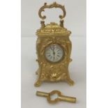 A miniature decorative, Regency style, gilt bronze carriage clock complete with key.