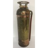 A vintage copper and brass 2½ gallon fire extinguisher with rubber hose.